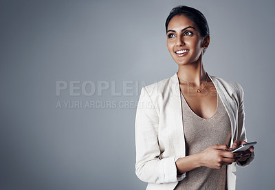 Buy stock photo Studio shot of a young businesswoman using a phone against a gray background