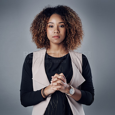 Buy stock photo Studio portrait of a young businesswoman posing against a gray background