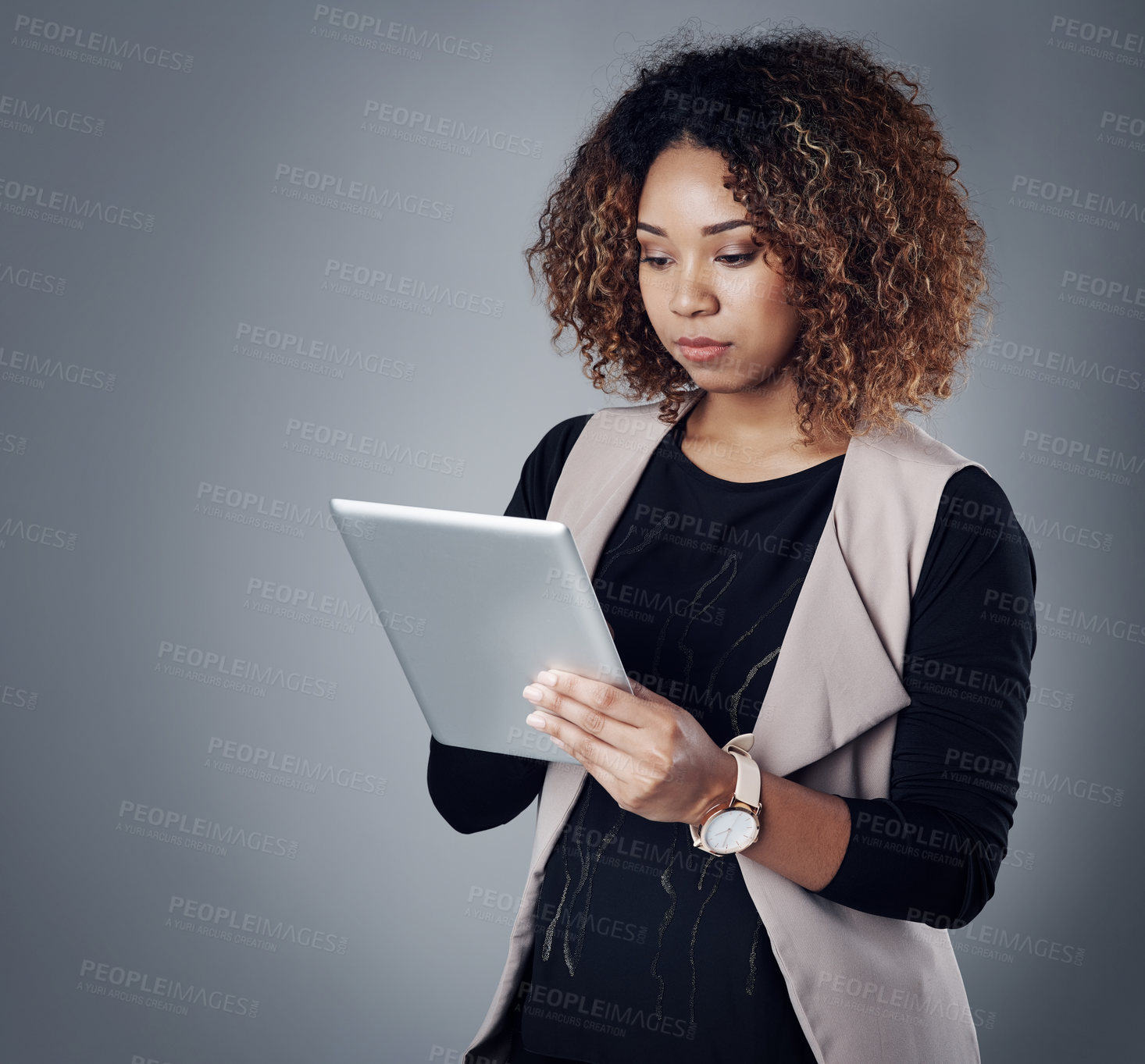 Buy stock photo Studio shot of a young businesswoman using a digital tablet against a gray background