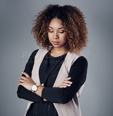 Buy stock photo Studio shot of a young businesswoman looking pensive against a gray background