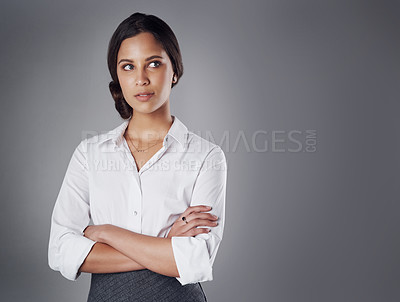 Buy stock photo Studio shot of a young businesswoman posing against a gray background