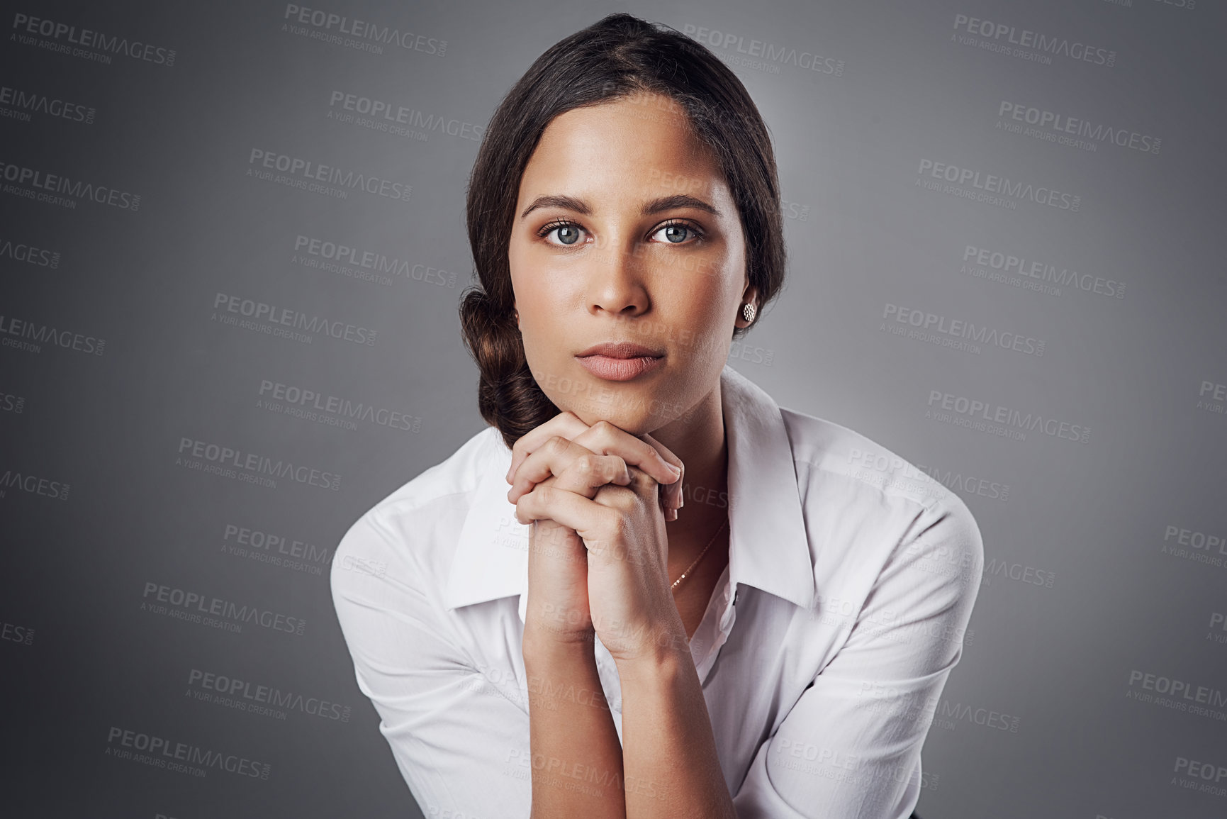 Buy stock photo Studio portrait of a young businesswoman posing against a gray background