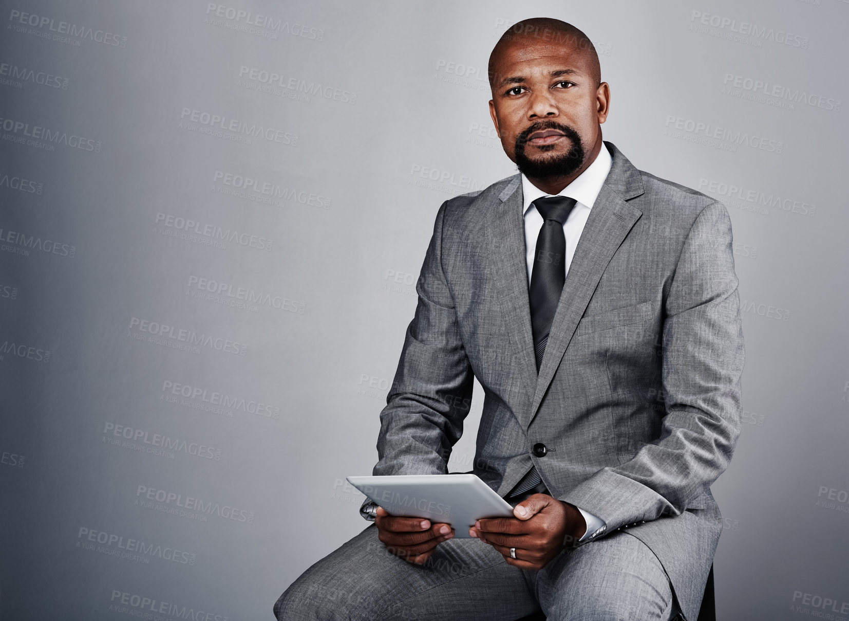 Buy stock photo Portrait, tablet and black man with serious ceo and management consultant in studio. Corporate, entrepreneur and sitting executive with leader and mockup from business success with grey background