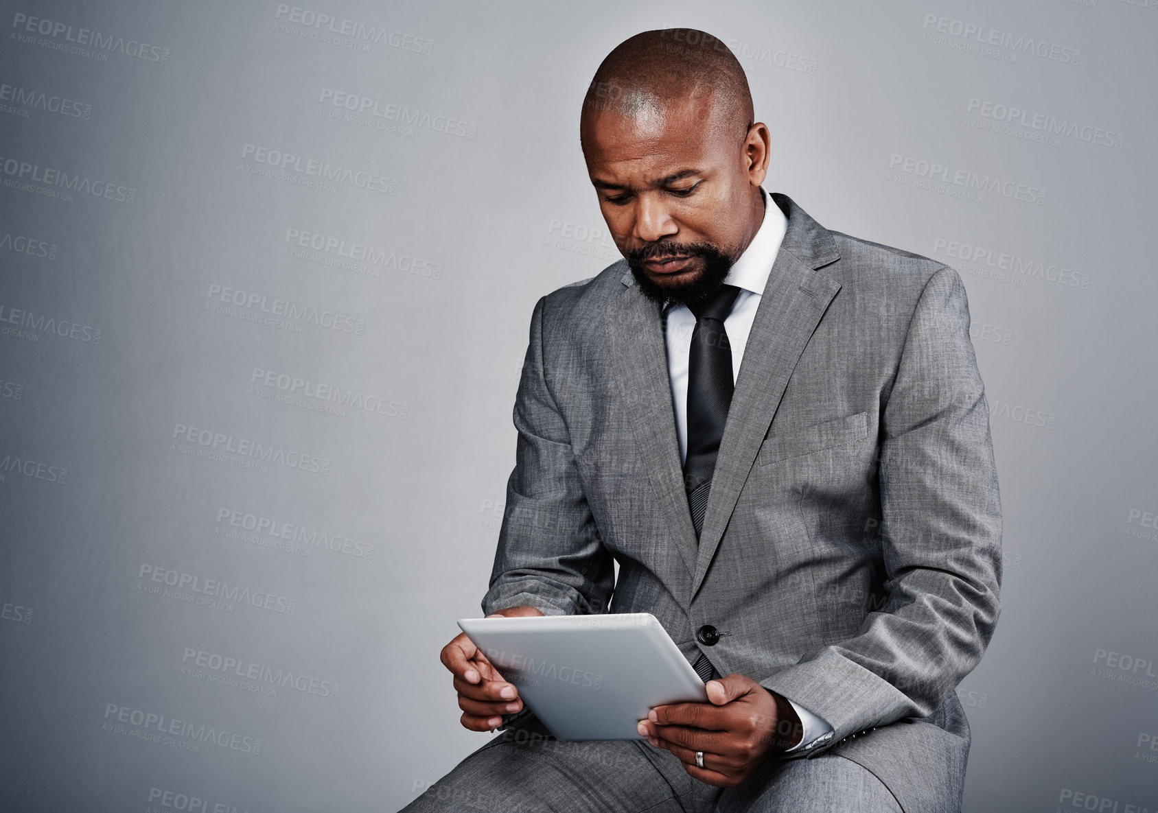 Buy stock photo Studio, black man and business with tablet for reading, online information and review update for case. Mockup space, male person and lawyer with digital for email feedback, justice or gray background