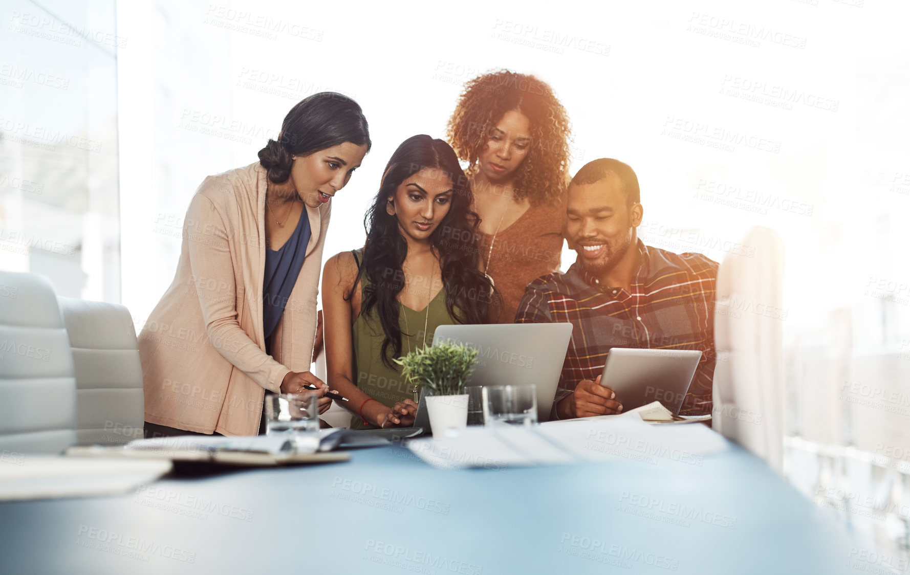 Buy stock photo Shot of a group of young professionals using wireless technology together in a meeting