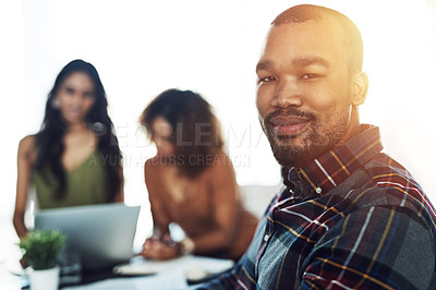 Buy stock photo Portrait of a confident young man having a meeting with his colleagues in the background