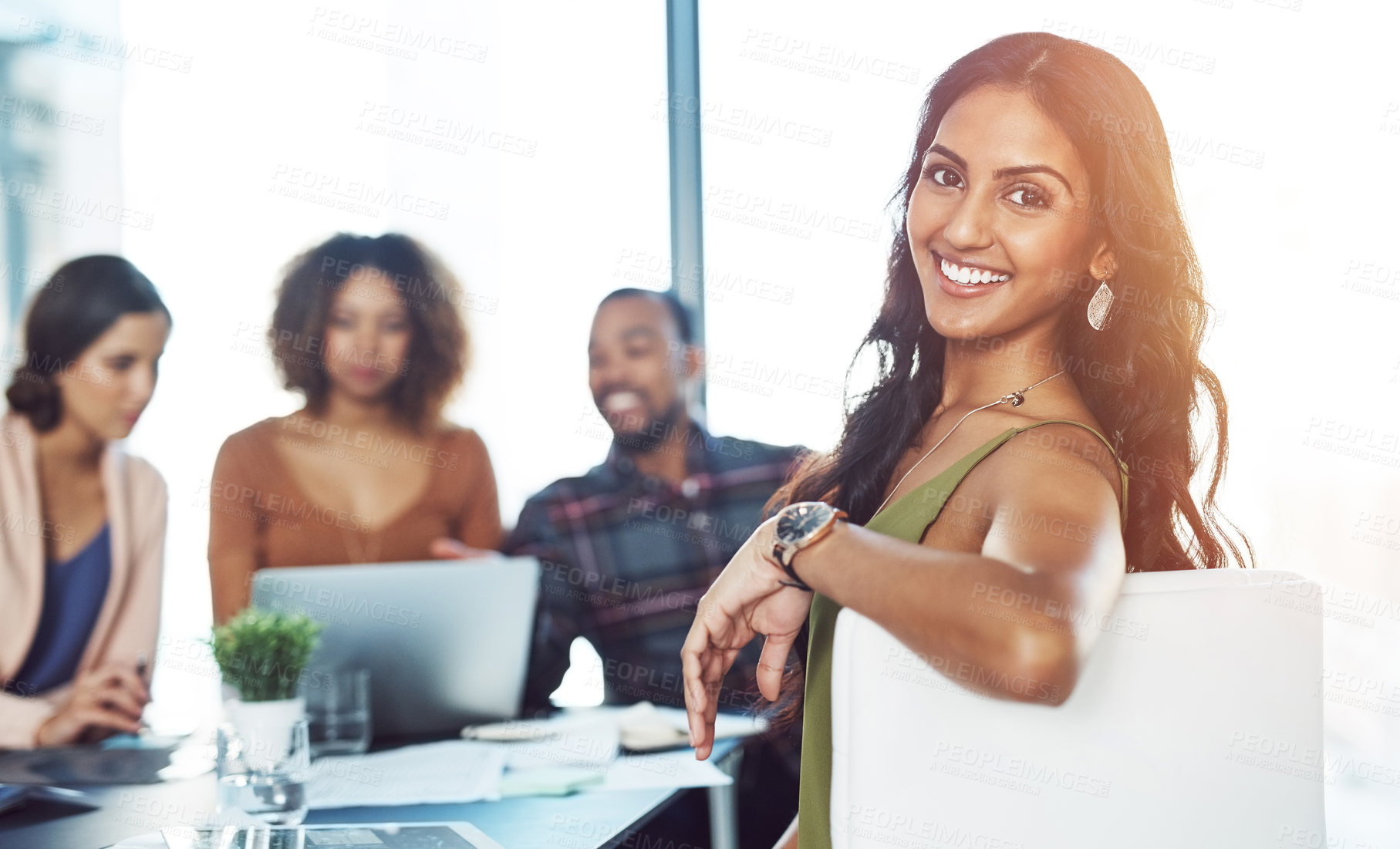 Buy stock photo Portrait of a confident young woman having a meeting with her colleagues in the background