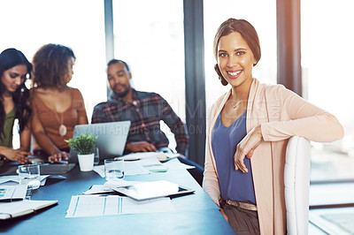 Buy stock photo Portrait of a confident young woman having a meeting with her colleagues in the background