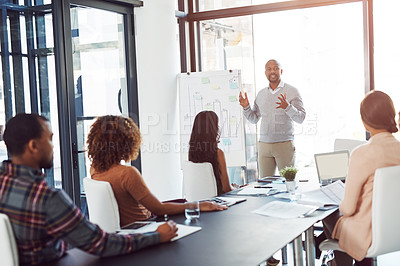Buy stock photo A businessman giving a presentation to coworkers in the boardroom