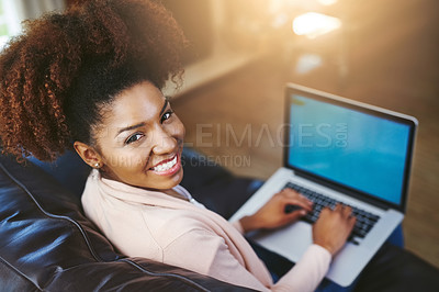 Buy stock photo High angle portrait of an attractive young woman using laptop while chilling at home on the sofa