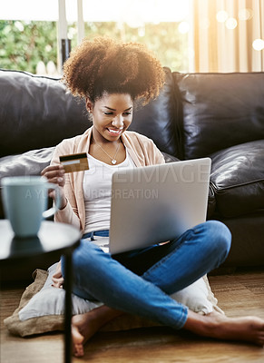 Buy stock photo Shot of an attractive young woman shopping online while chilling at home on the sofa