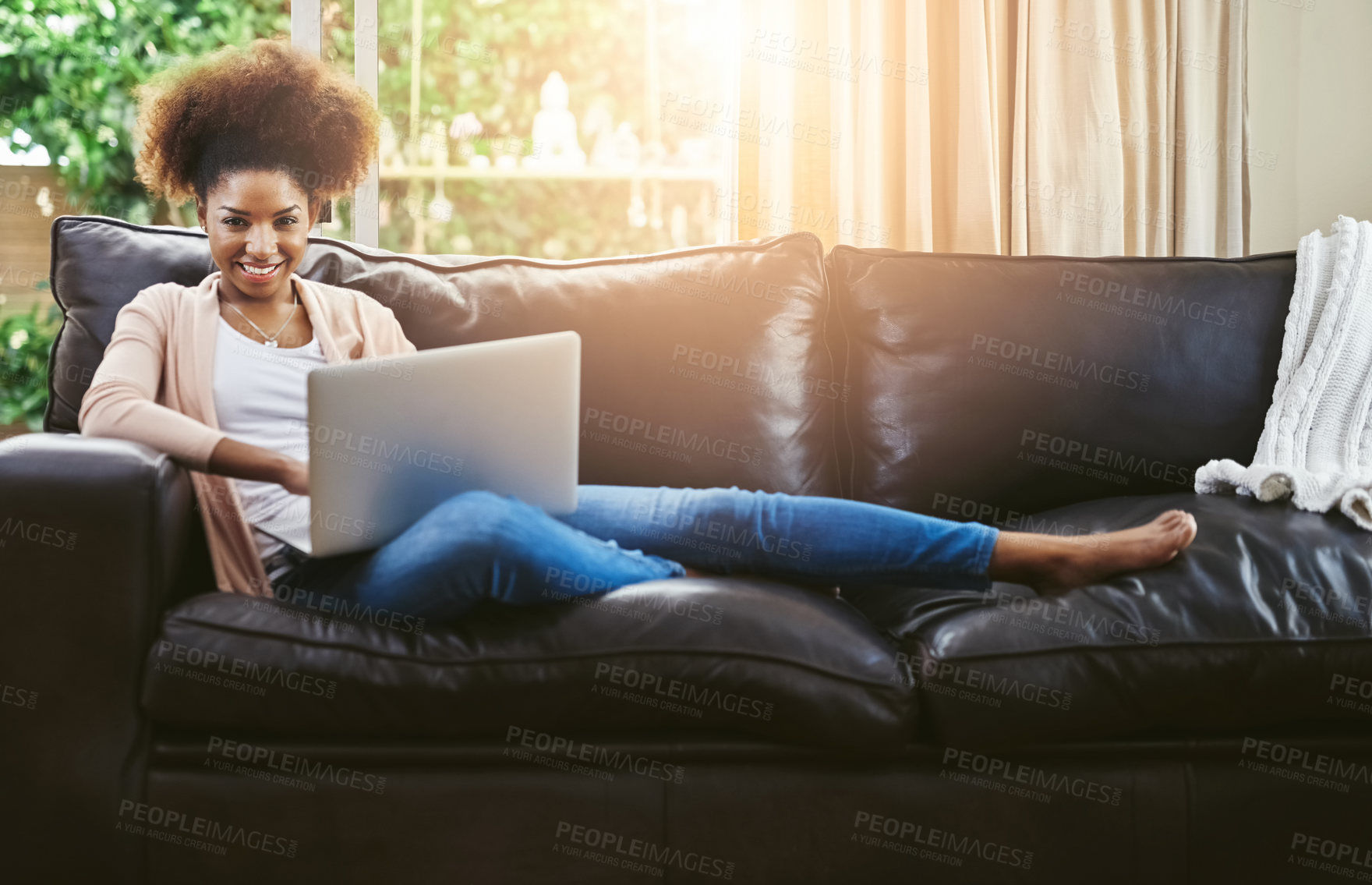 Buy stock photo Portrait of an attractive young woman using laptop while chilling at home on the sofa