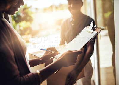 Buy stock photo High angle shot of an unrecognizable woman signing for a home delivery