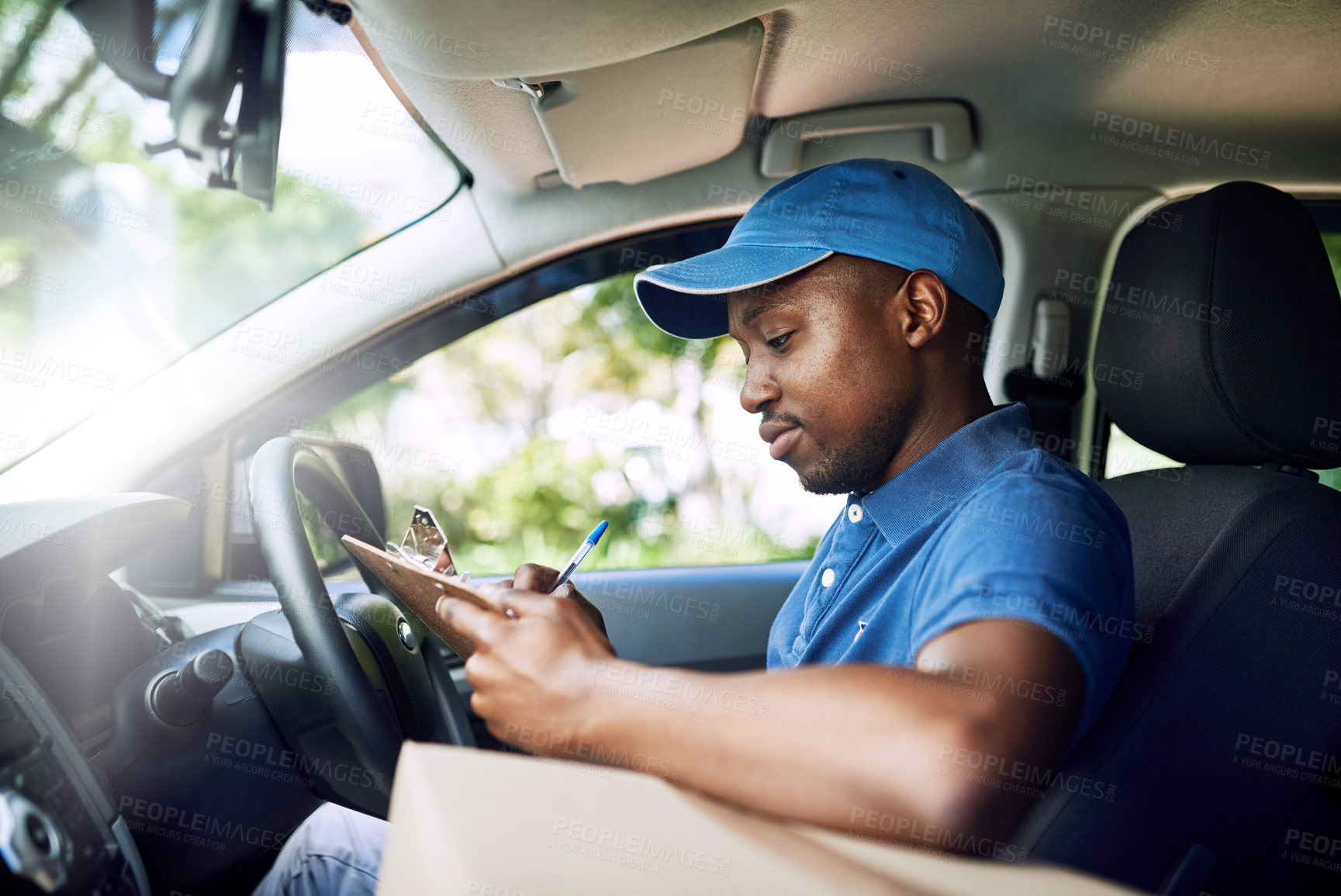 Buy stock photo African delivery man, writing and checklist in car with boxes, stock and thinking at job in supply chain. Person, courier and pen for invoice with clipboard, shipping and transportation for logistics