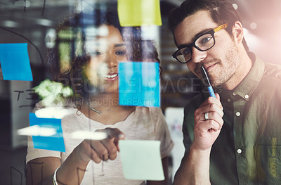 Buy stock photo Cropped shot of two young designers planning on a glass board