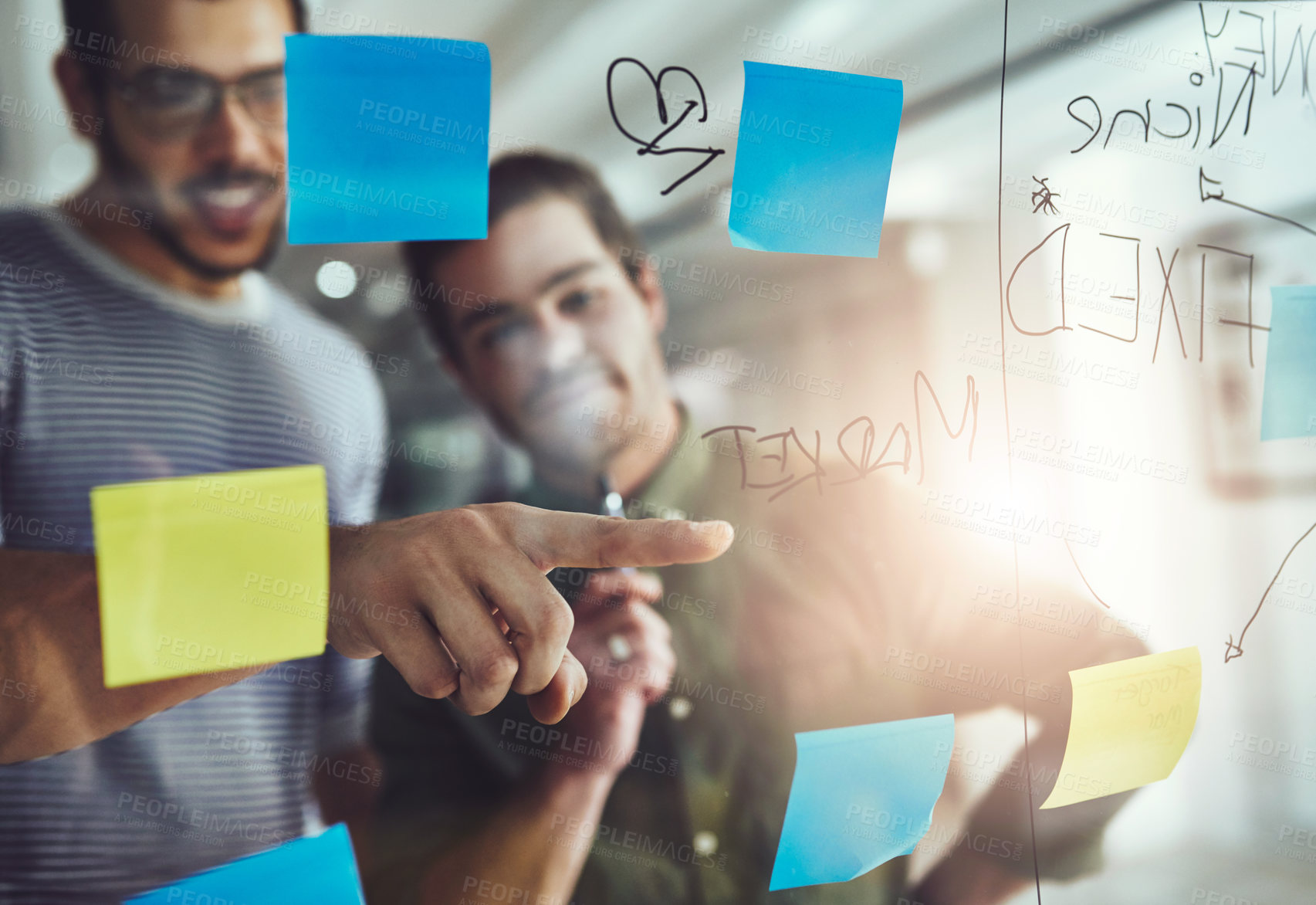 Buy stock photo Cropped shot of two young designers planning on a glass board