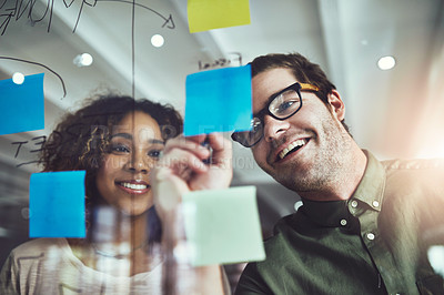 Buy stock photo Cropped shot of two young designers planning on a glass board