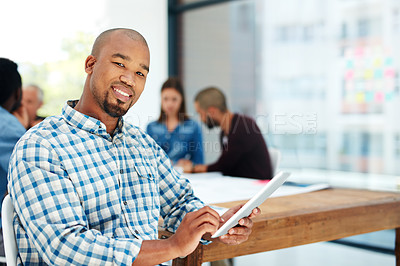 Buy stock photo Portrait of a handsome young man using his tablet while sitting in the boardroom during a meeting