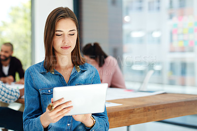 Buy stock photo Shot of an attractive young woman using her tablet while sitting in the boardroom during a meeting