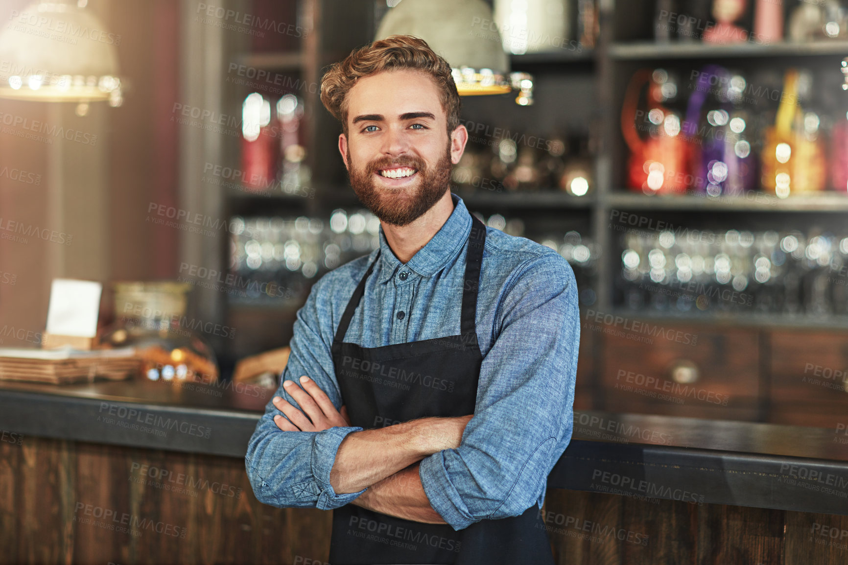 Buy stock photo Happy, smile and portrait of coffee shop owner standing by the counter in his startup cafeteria. Happiness, success and male barista with small business with crossed arms for confidence in restaurant