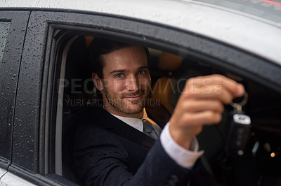 Buy stock photo Shot of a smiling businessman holding keys while sitting in his new car