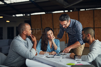 Buy stock photo Shot of a group of designers using a digital tablet in their meeting