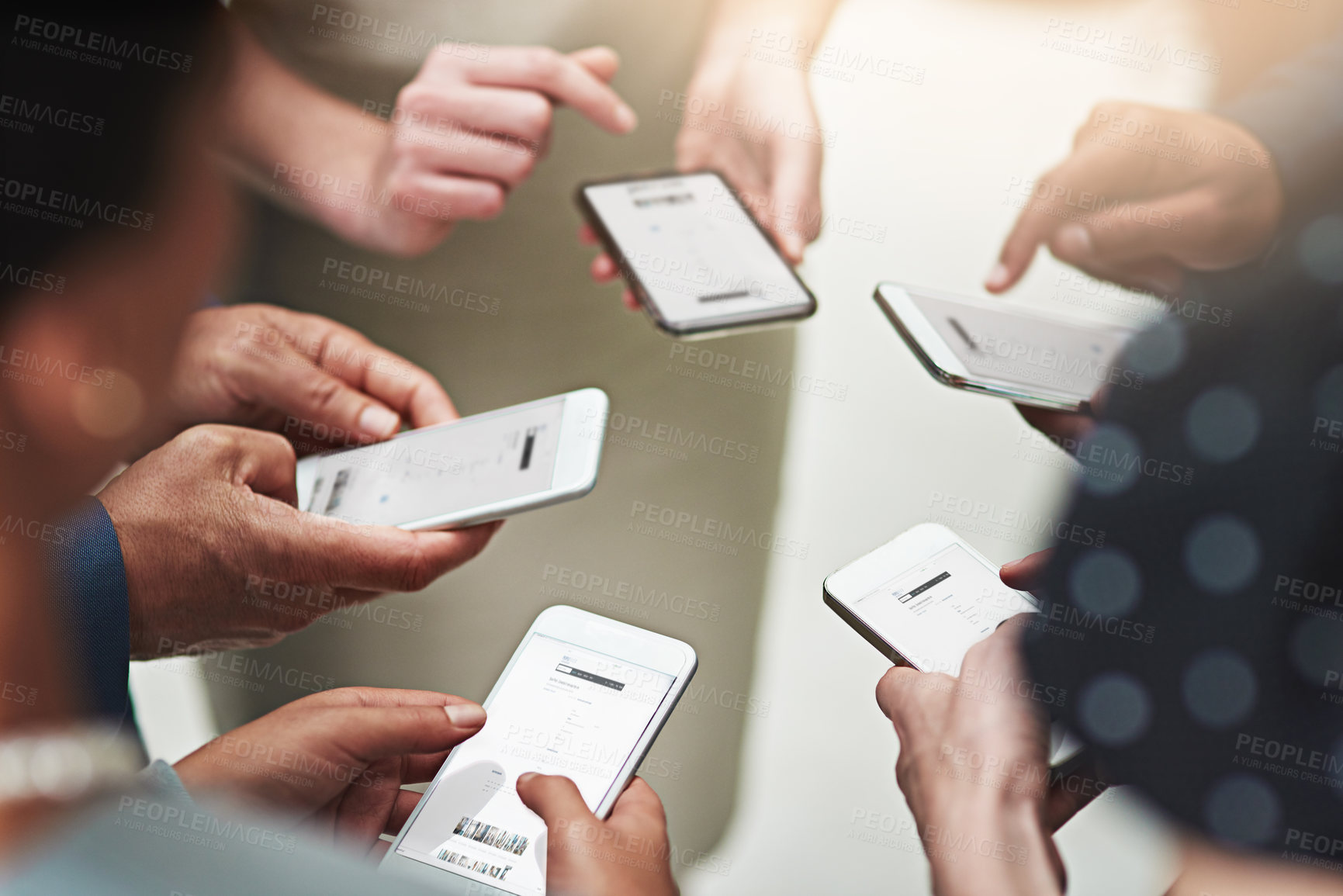 Buy stock photo Cropped shot of a group of unrecognisable businesspeople texting on their cellphones in an office