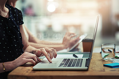 Buy stock photo Cropped shot of an unrecognisable businesswoman working on a laptop in an office