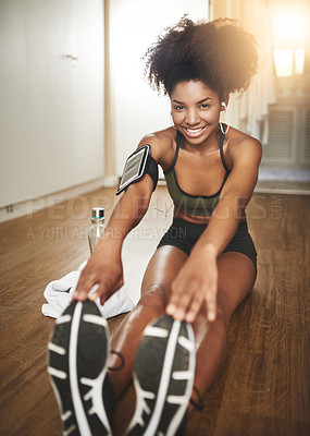 Buy stock photo Shot of a young woman doing stretching exercises at home