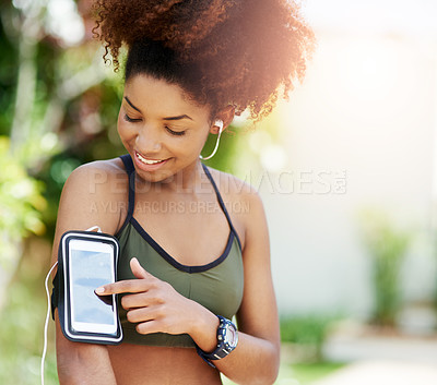 Buy stock photo Cropped shot of a young woman starting her playlist before her run