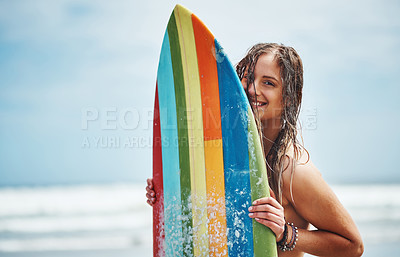 Buy stock photo Portrait of an attractive young woman standing on a beach with a surfboard
