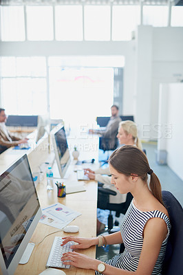 Buy stock photo Shot of a group of young designers working at their computers in an office
