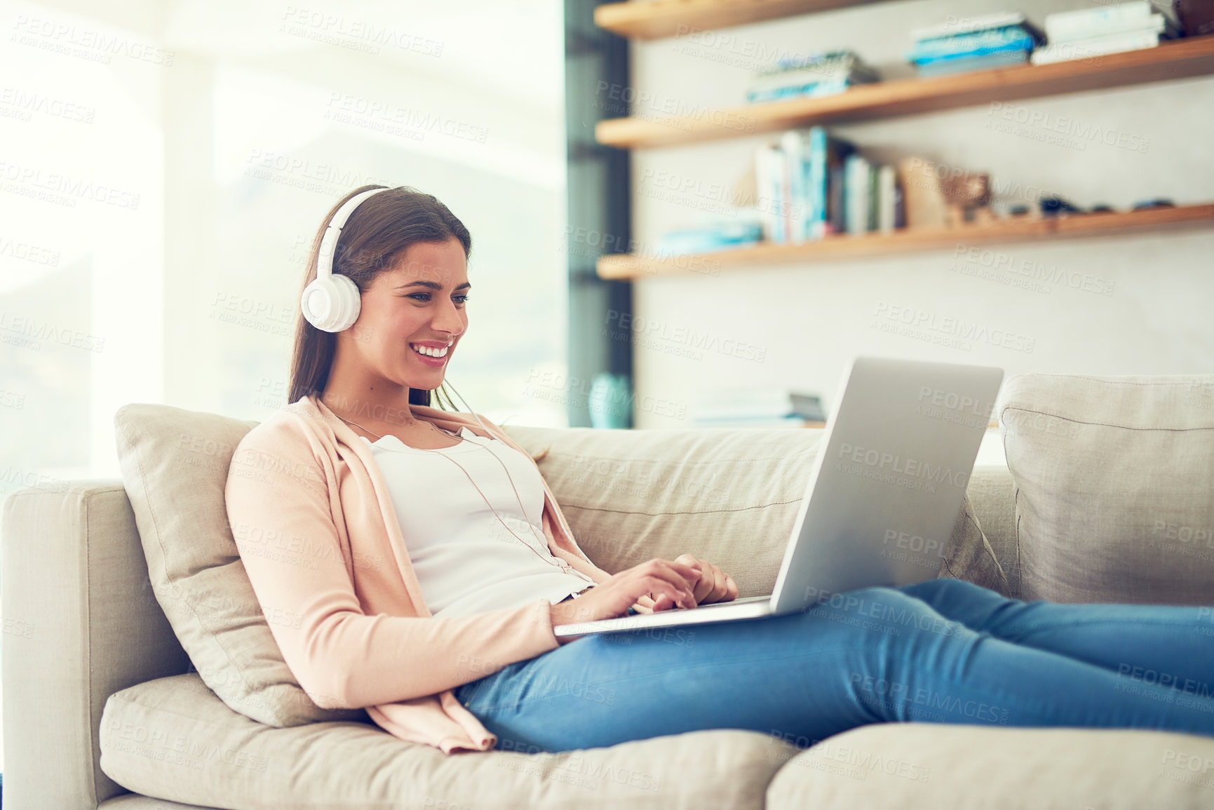 Buy stock photo Woman, laptop and happy with headphones on sofa in home for audio streaming, subscription service and social media. Person, music and watching series with movie entertainment, radio playlist or sound