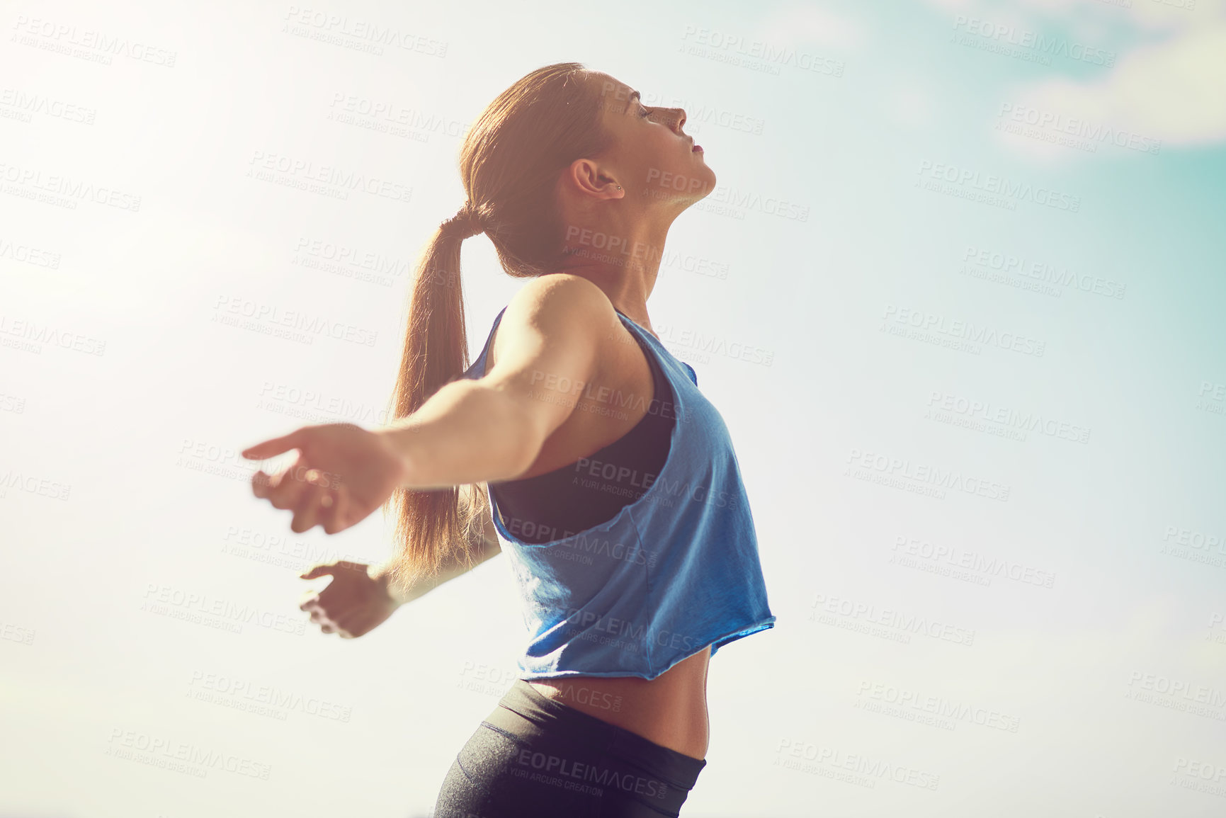 Buy stock photo Cropped shot of a young woman standing with her arms outstretched