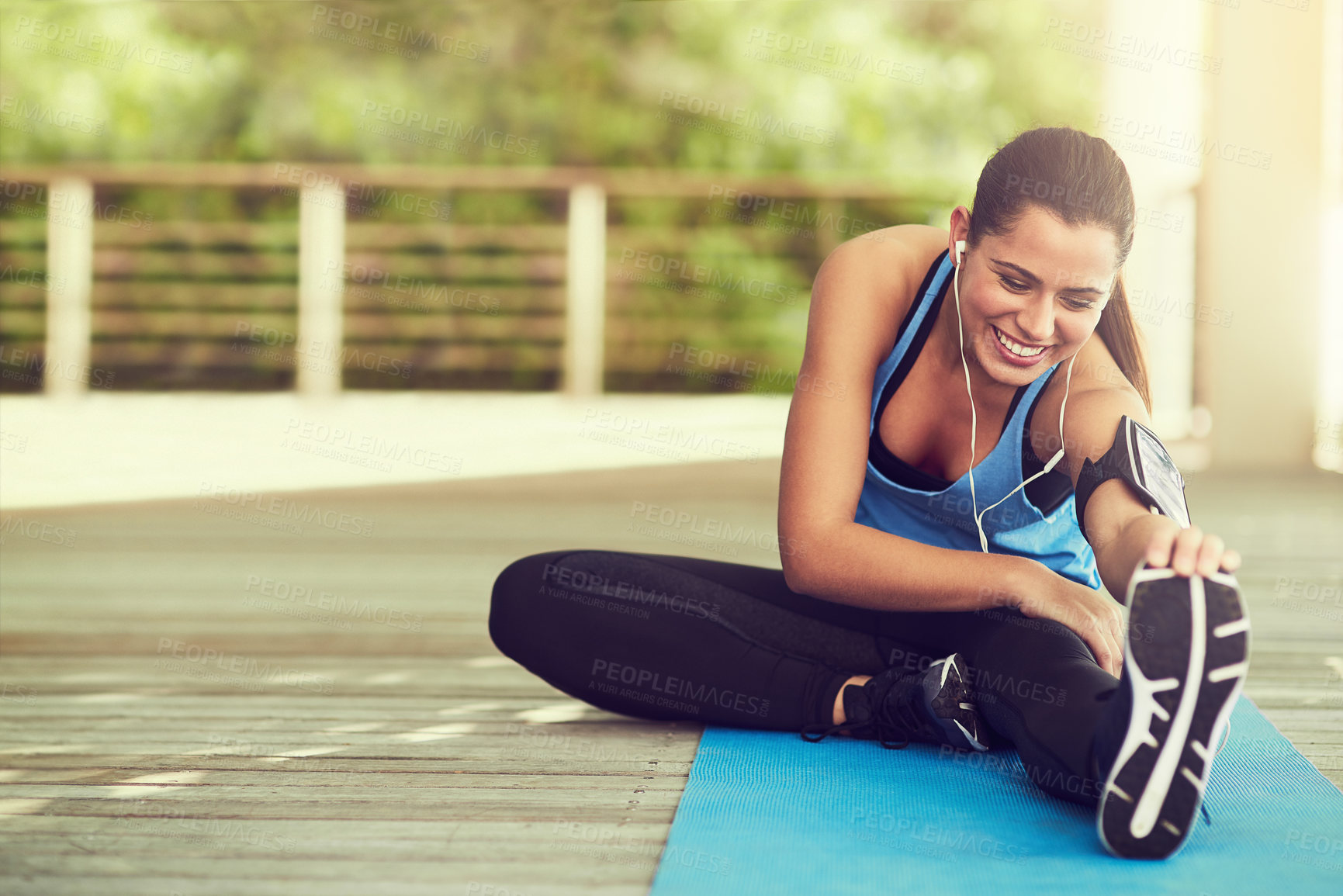 Buy stock photo Head to knee, yoga and woman stretching in home for fitness, wellness or body health. Forward bend, smile and flexible person exercise in pilates pose while listening to music on earphones outdoor