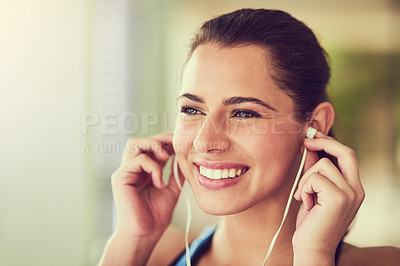 Buy stock photo Cropped shot of a young woman putting in her earphones before working  out