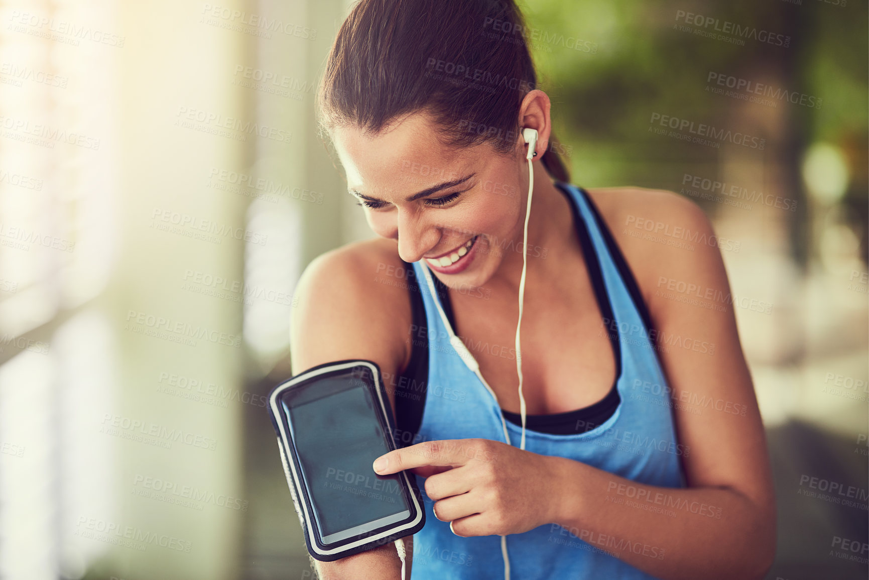 Buy stock photo Shot of a young woman starting her playlist before working out