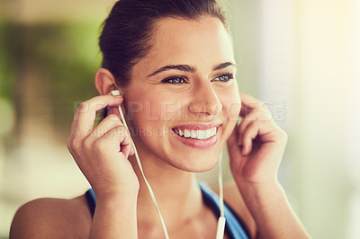 Buy stock photo Cropped shot of a young woman putting in her earphones before working  out