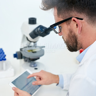 Buy stock photo Cropped shot of a male scientist working on a digital tablet in a lab