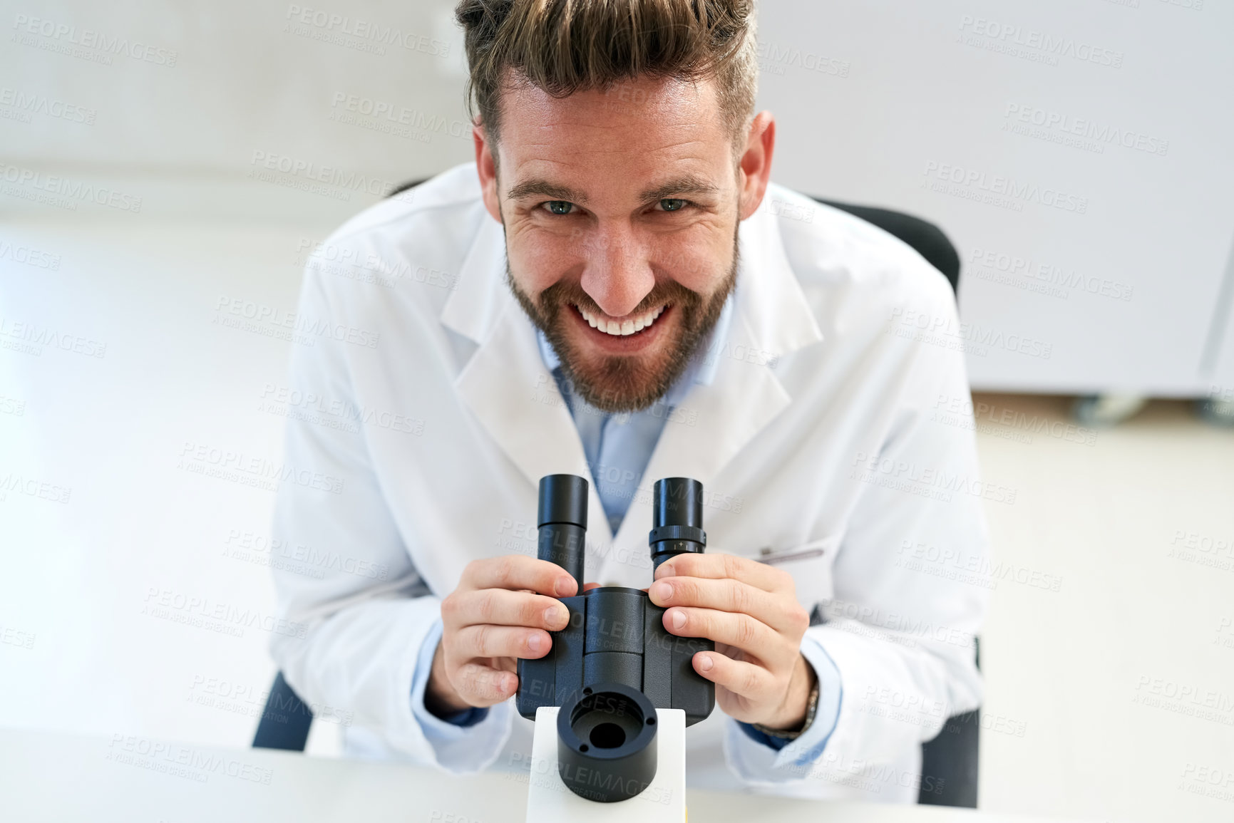 Buy stock photo Portrait of a male scientist using a microscope in a lab