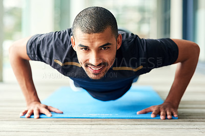 Buy stock photo Portrait of a sporty young man doing pushups outside