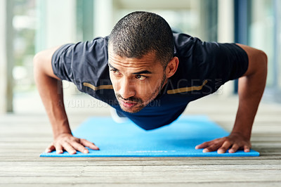 Buy stock photo Shot of a sporty young man doing pushups outside