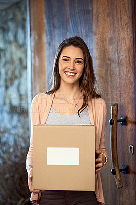 Buy stock photo Portrait of a smiling young woman carrying a box while moving into her new house