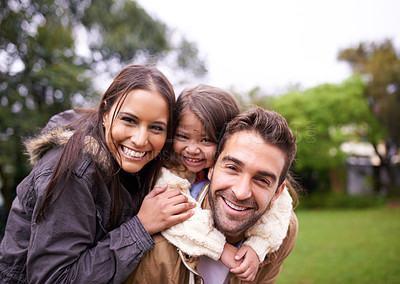 Buy stock photo Shot of a young family of three enjoying a day in the park