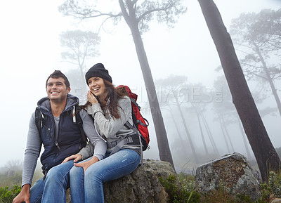 Buy stock photo Shot of a young couple taking a break while out hiking