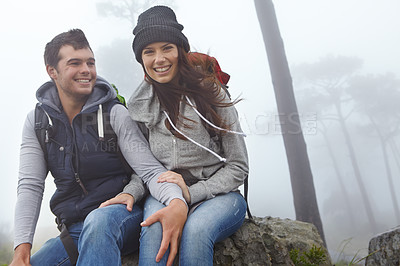 Buy stock photo Shot of a young couple taking a break while out hiking