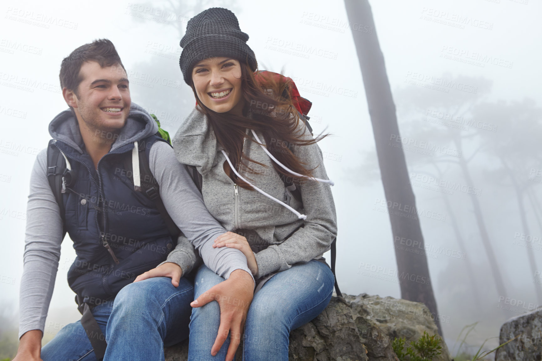 Buy stock photo Shot of a young couple taking a break while out hiking