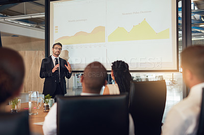 Buy stock photo Shot of an executive giving a presentation on a projection screen to a group of colleagues in a boardroom