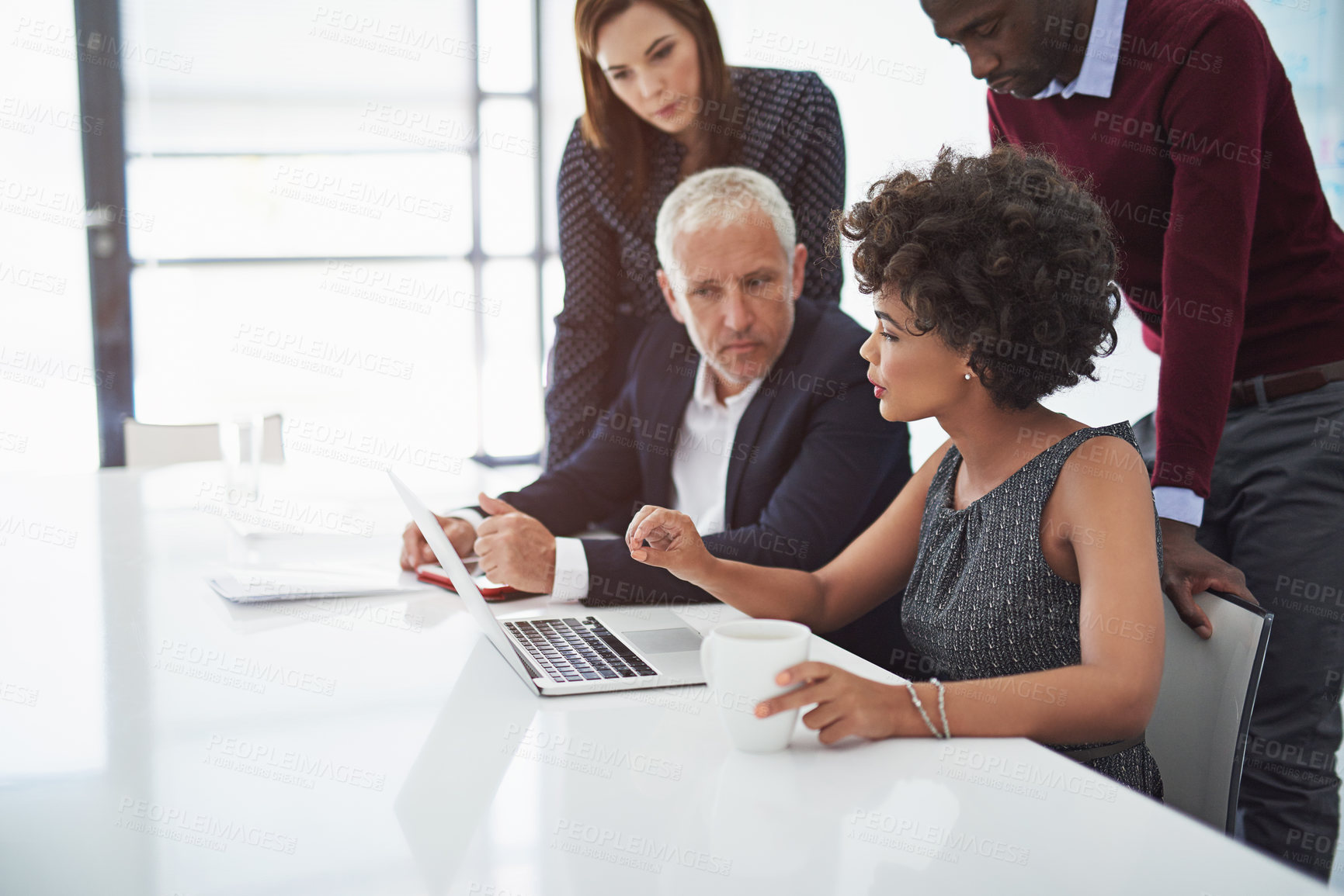 Buy stock photo Cropped shot of a group of businesspeople discussing something on a laptop