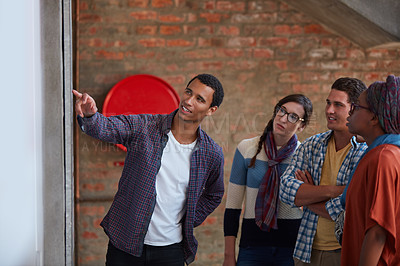 Buy stock photo Cropped shot of a group of university students looking at a notice on a wall